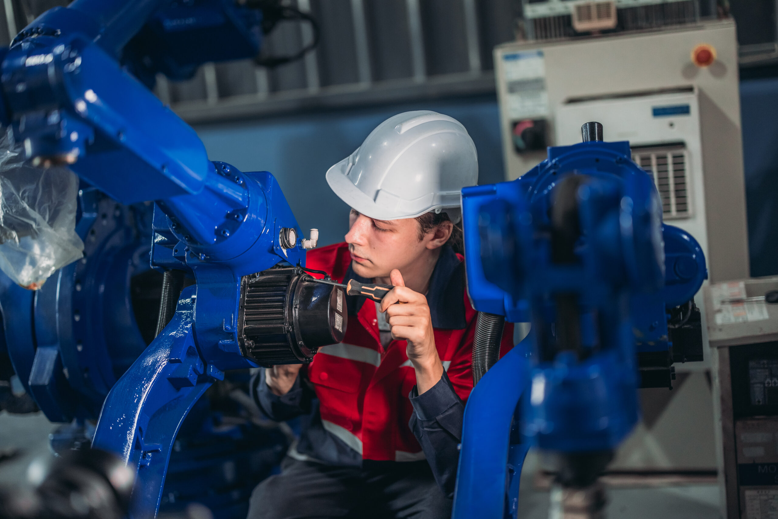 Robotic technician conduct specialized maintenance on an industrial robotic arm in a manufacturing plant.